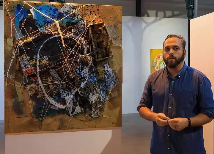 Pedro Palrão junto à sua obra na exposição 100×100